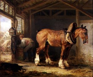 A groom with carthorse in a stable